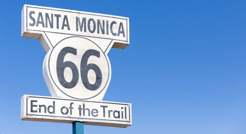 Route 66 End of the Trail sign in Santa Monica against a deep blue sky